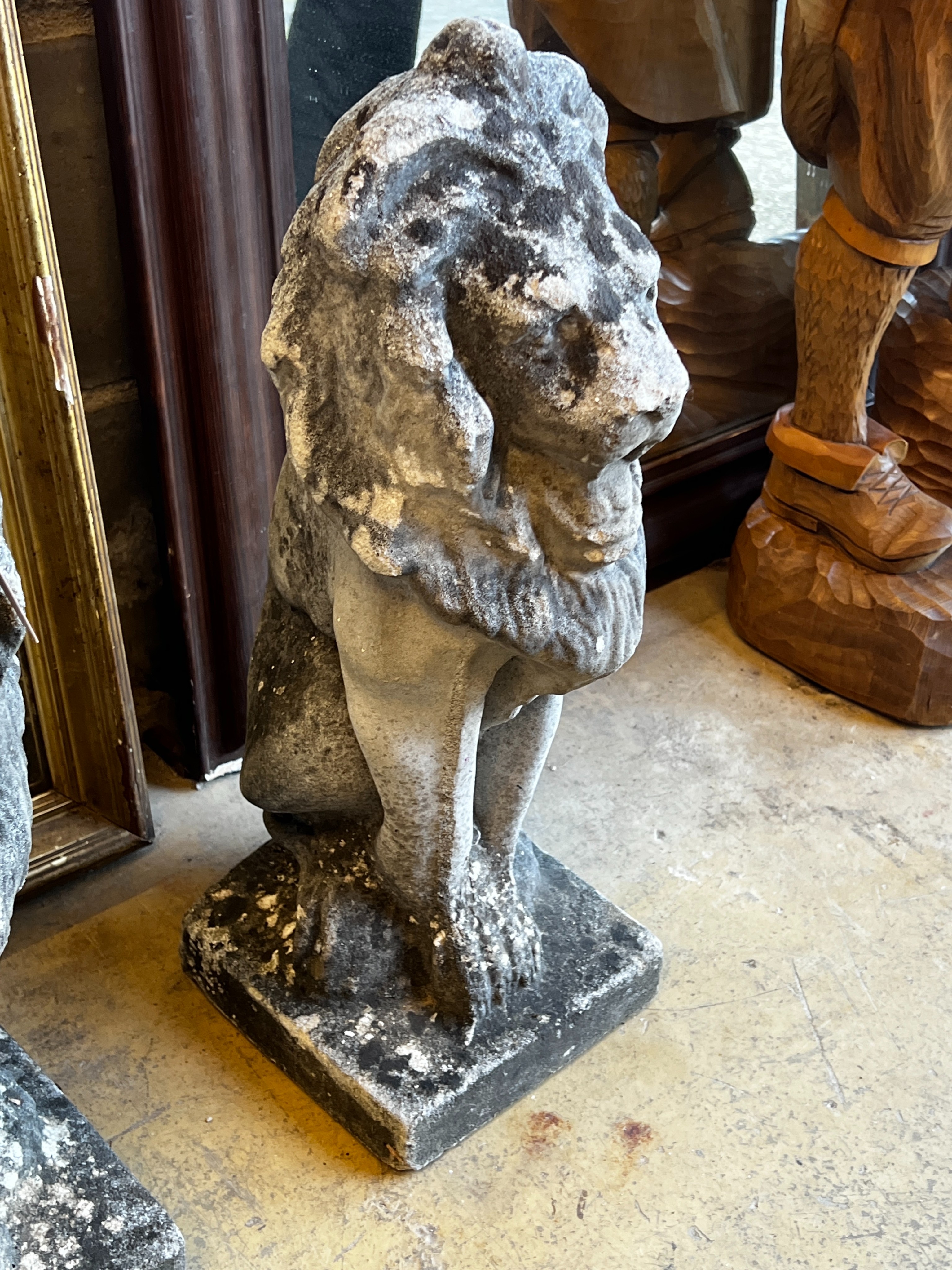 A pair of reconstituted stone seated lion garden ornaments, height 55cm